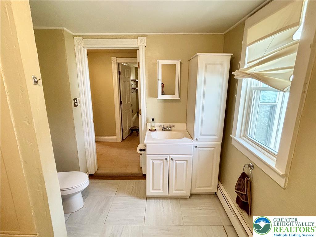 7241 Decatur Street New Tripoli, PA 18066 - Photo 24 of 36 A well-lit bathroom features a vanity with ample storage and a window allowing natural light to flow in.
