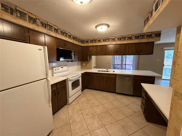 a kitchen with stainless steel appliances a stove a refrigerator a sink dishwasher and a stove with wooden floor