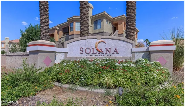 a view of a brick house with a yard and potted plants