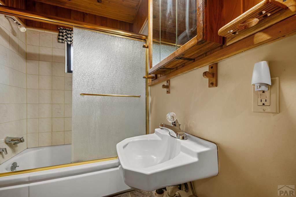 9600 Middle Creek Canyon Road Beulah, CO 81023 - Photo 23 of 50 a bathroom with a sink a mirror and a shower