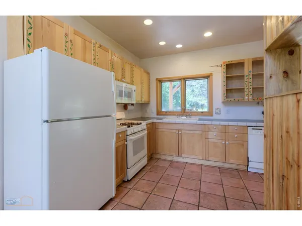 a kitchen with a sink a counter top space stainless steel appliances and cabinets