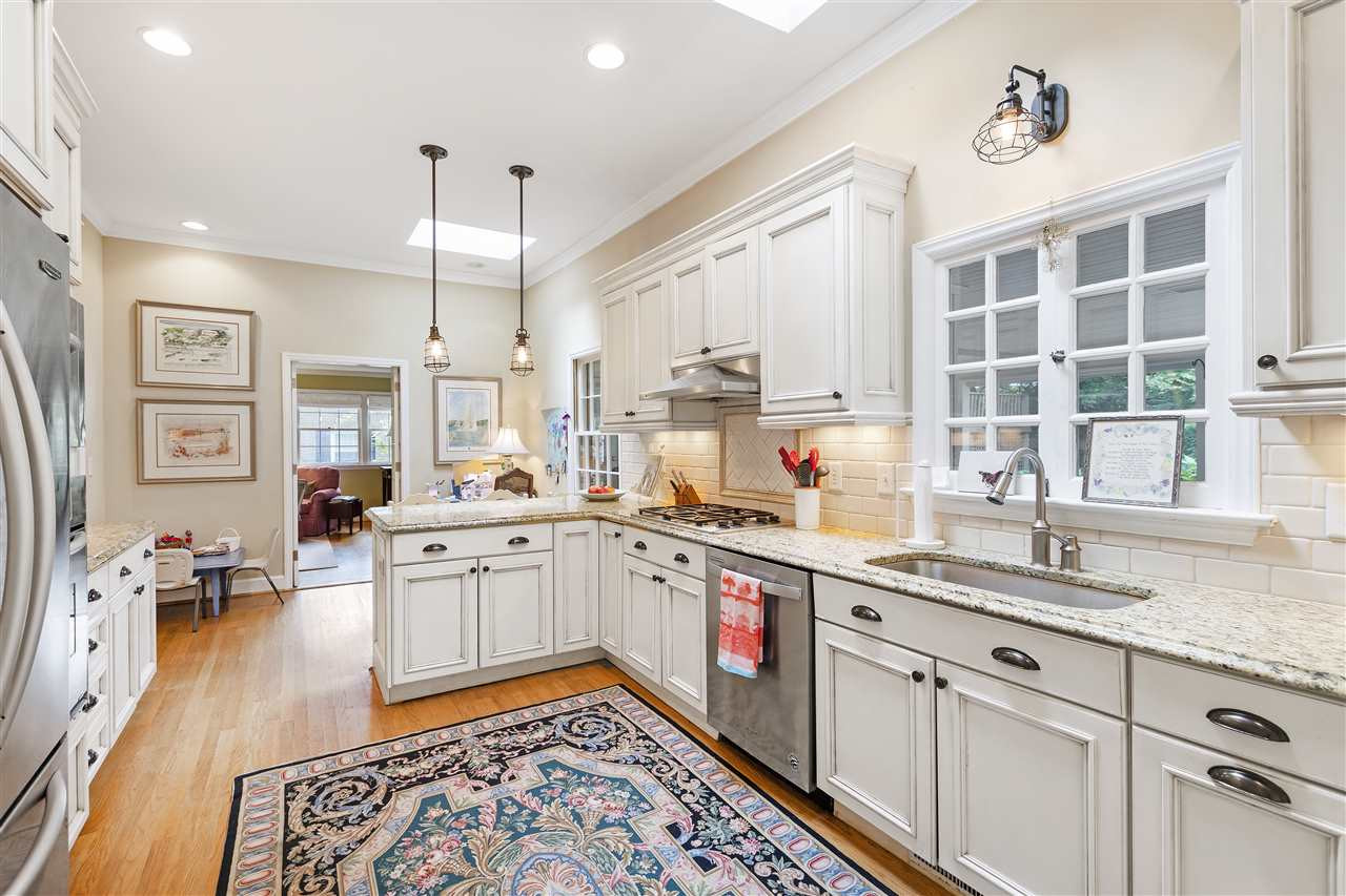 608 Sampson Street Raleigh, NC 27609 - Photo 9 of 30 a open kitchen with stainless steel appliances granite countertop a sink dishwasher a dining table and chairs with wooden floor