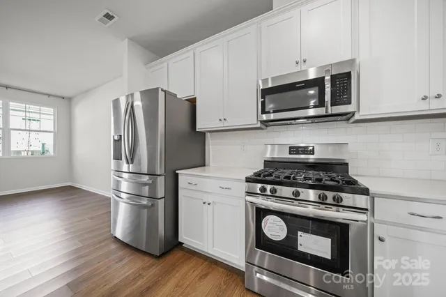 a kitchen with appliances a microwave and cabinets