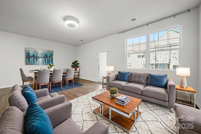 a living room with furniture a large window and a table