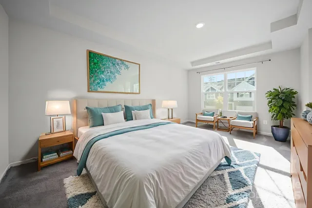 a spacious bedroom with a bed a table and a potted plant