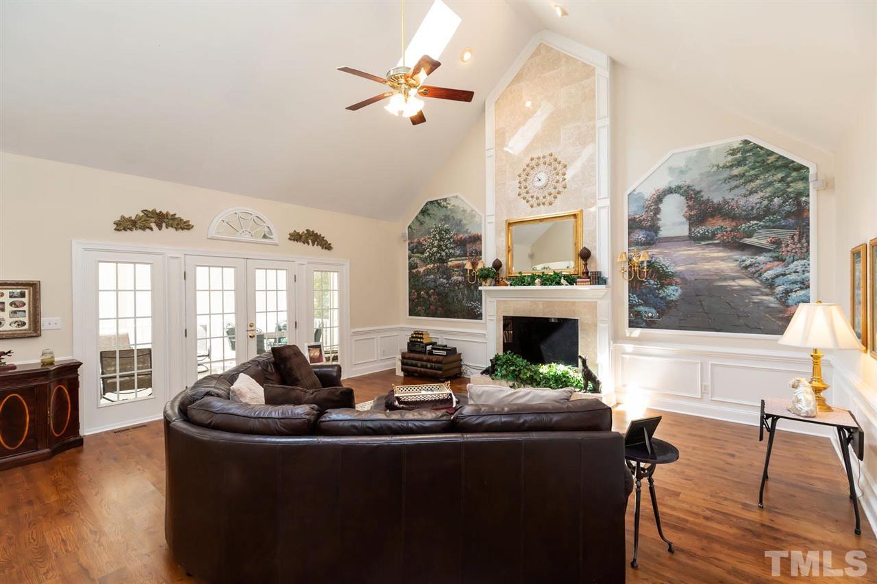 12613 Raven Ridge Road Raleigh, NC 27614 - Photo 7 of 29 a living room with furniture a fireplace and a floor to ceiling window