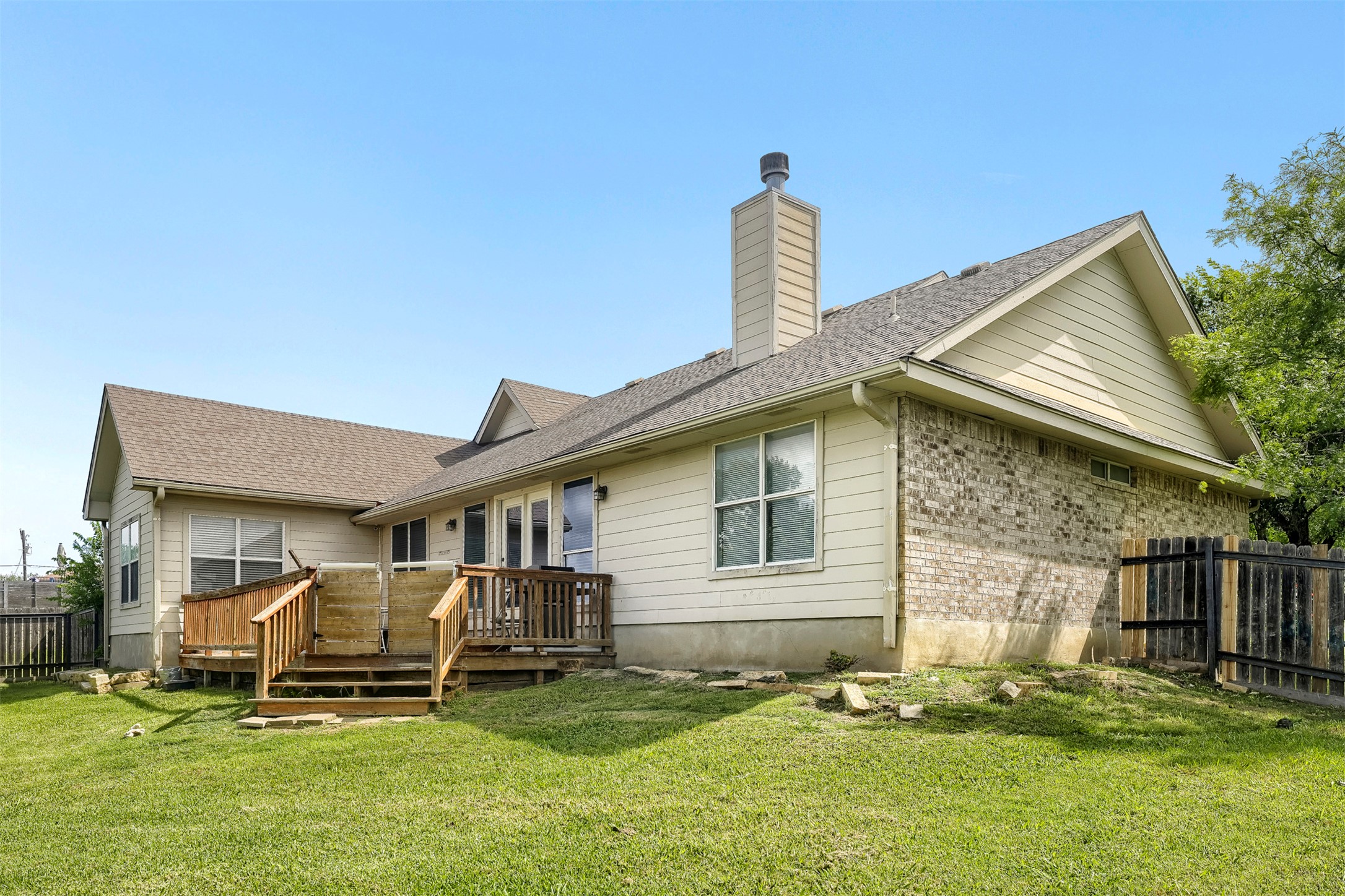 1105 2nd Street Jarrell, TX 76537 - Photo 24 of 27 A spacious backyard features a multi-level wooden deck perfect for outdoor enjoyment and entertaining.