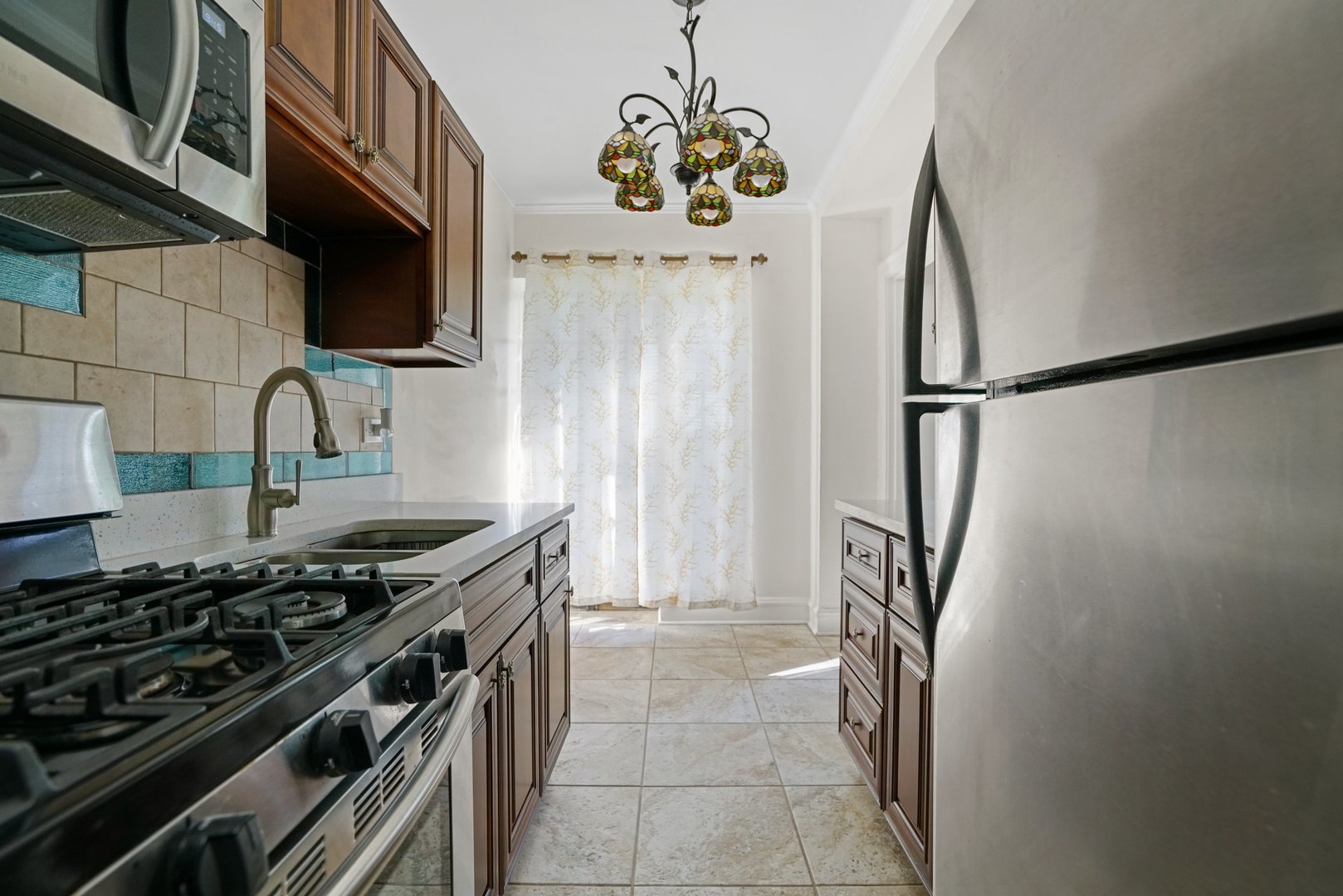 3017 East 78th Street, Unit 2B Chicago, IL 60649 - Photo 12 of 20 a kitchen with stainless steel appliances granite countertop a stove and a refrigerator
