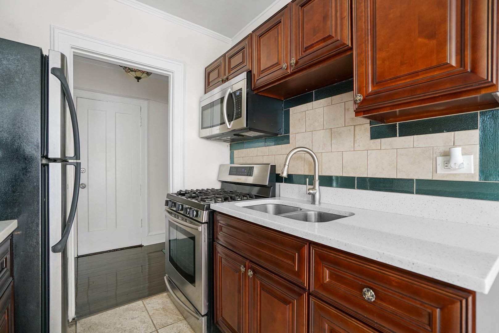 3017 East 78th Street, Unit 2B Chicago, IL 60649 - Photo 10 of 20 a kitchen with stainless steel appliances granite countertop a sink stove and refrigerator