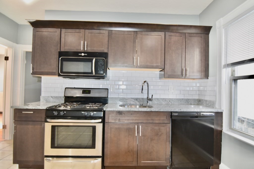 21 Treadway Road, Unit 2 Boston, MA 02125 - Photo 3 of 21 a kitchen with granite countertop a sink stainless steel appliances and cabinets