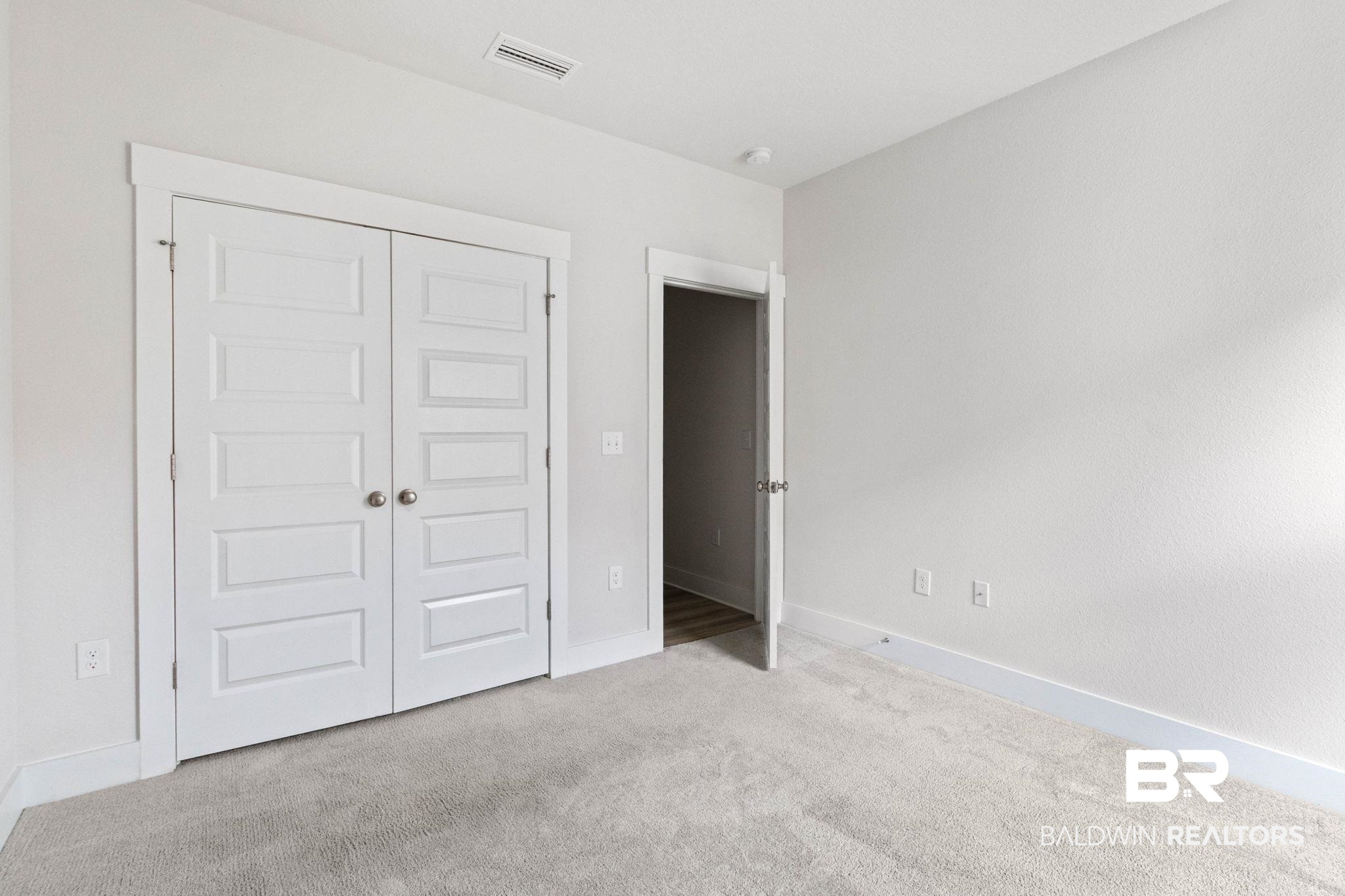 1710 Grouse Street Foley, AL 36535 - Photo 51 of 76 Bedroom featuring light grey carpeting, white walls, wide baseboards, and a white paneled closet door