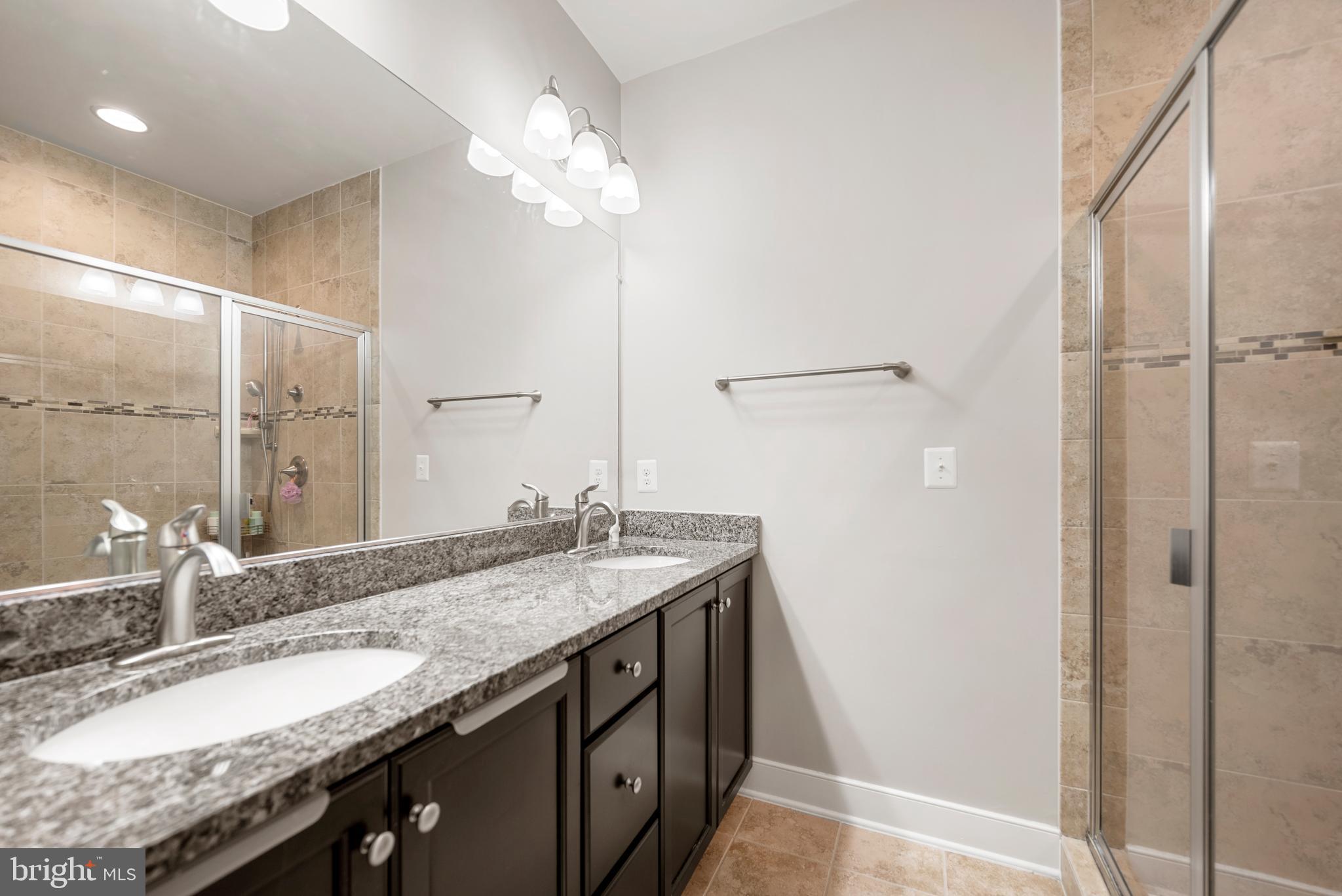 710 East Howell Avenue Alexandria, VA 22301 - Photo 18 of 43 a bathroom with a granite countertop sink a mirror and a shower