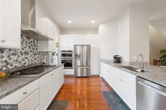 a kitchen with granite countertop a sink stove and refrigerator