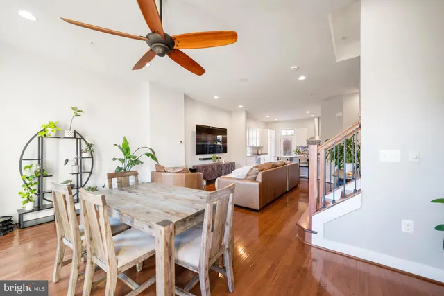 a living room with furniture kitchen view and a wooden floor