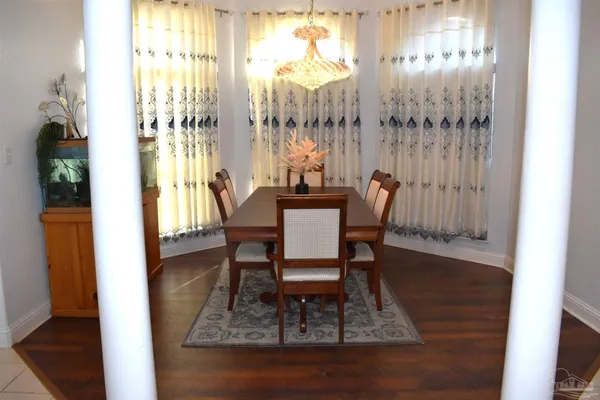 a dining room with furniture a chandelier and wooden floor