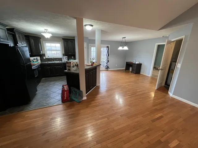 a view of a living room with kitchen view and a wooden floor