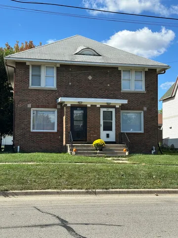 a view of a brick house with a yard next to a road