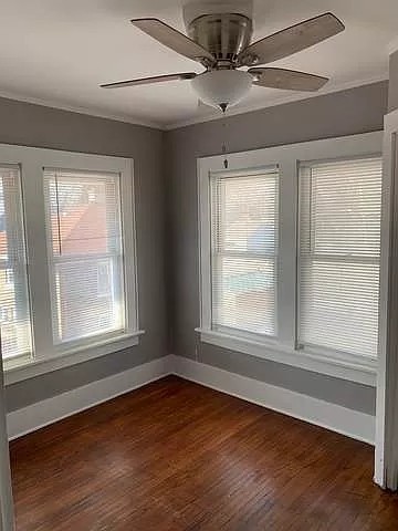 325 North 7th Street DeKalb, IL 60115 - Photo 11 of 20 an empty room with wooden floor chandelier and windows