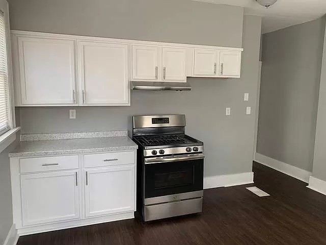 325 North 7th Street DeKalb, IL 60115 - Photo 4 of 20 a kitchen with granite countertop wooden cabinets and a stove top oven