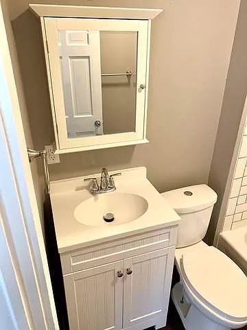 325 North 7th Street DeKalb, IL 60115 - Photo 10 of 20 a bathroom with a sink a toilet and a mirror