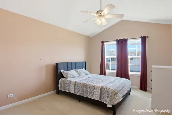 a bedroom with a bed and a ceiling fan