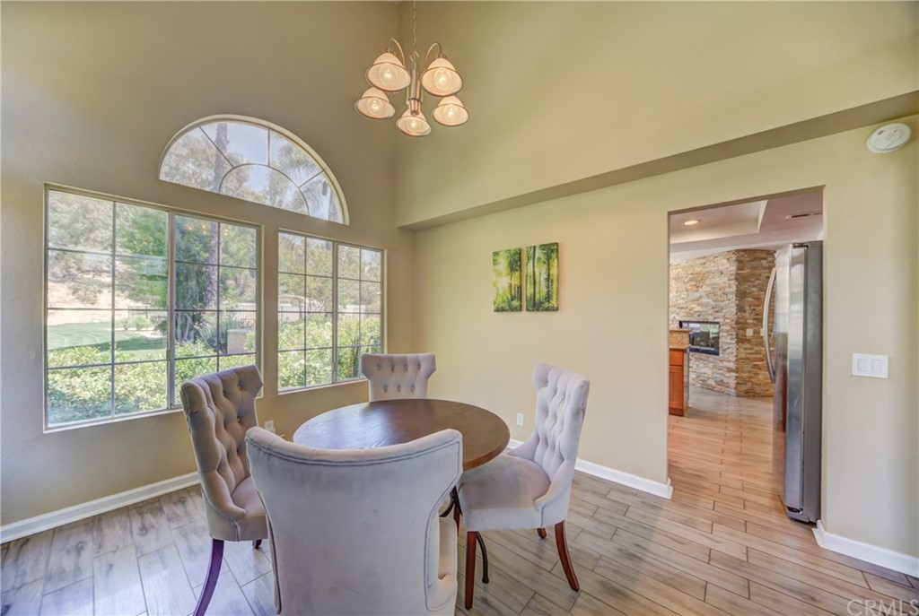 30219 Corte Cantera Temecula, CA 92591 - Photo 8 of 33 a view of a dining room with furniture a chandelier and wooden floor