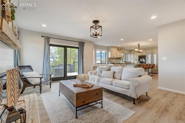 3405 Spaatz Road Monument, CO 80132 - Photo 14 of 47 Living room featuring a notable chandelier and light hardwood / wood-style flooring