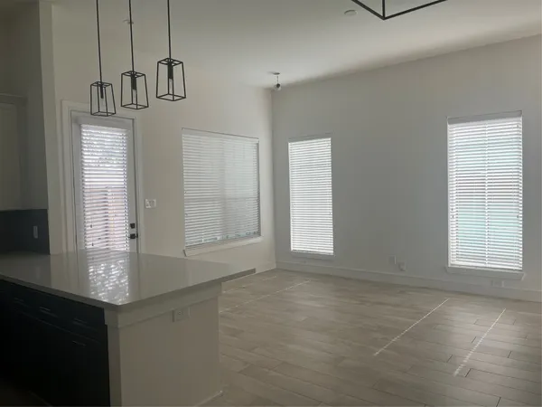 a view of an empty room with chandelier and window