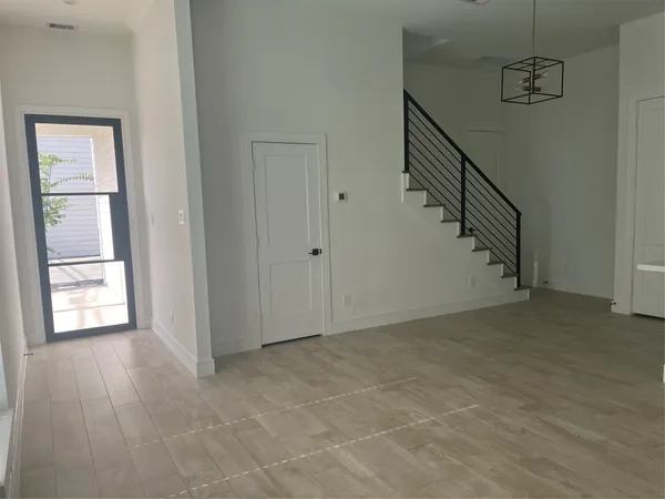 a view of an empty room with stairs and ventilation