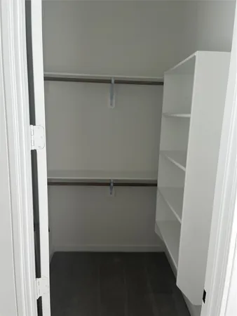 a view of walk in closet with empty racks