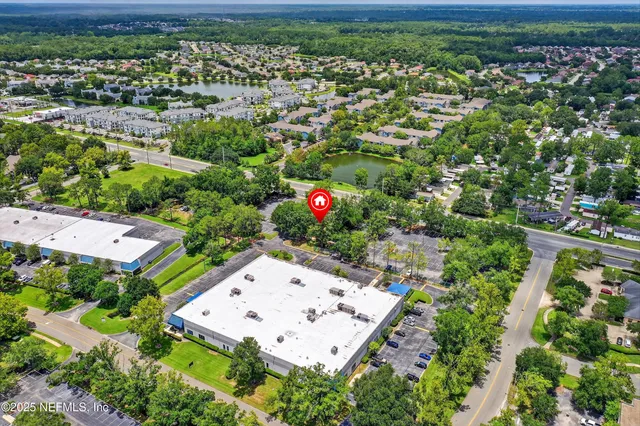 an aerial view of residential houses with outdoor space and trees