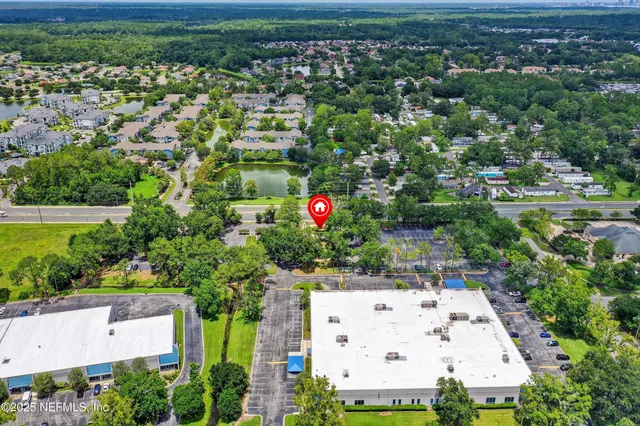 an aerial view of residential houses with outdoor space and trees