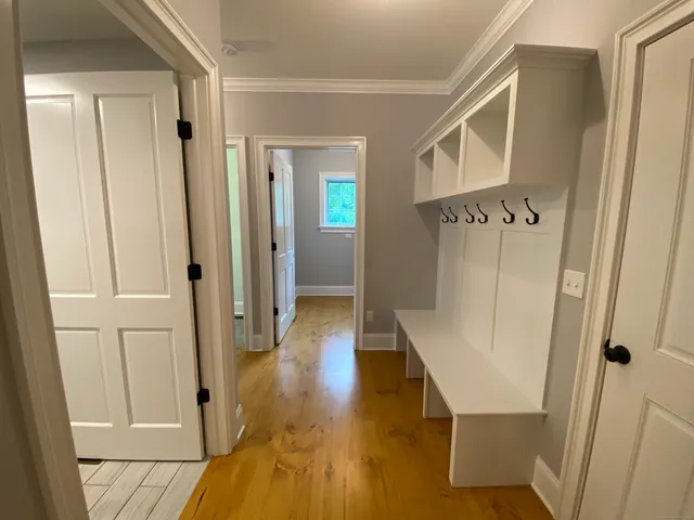 a view of a hallway with wooden floor and staircase