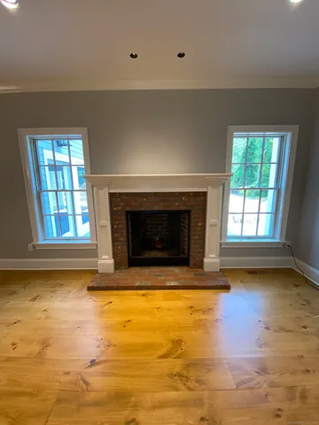 a view of empty room with floor to ceiling window and fireplace