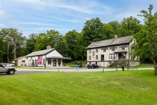 a view of house with garden and tall trees