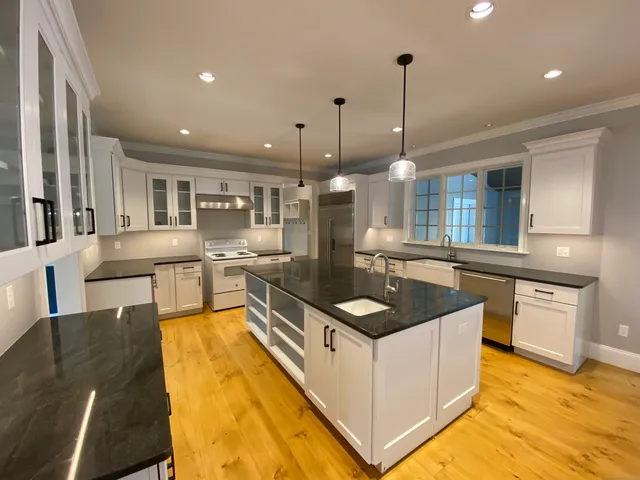 a kitchen with stainless steel appliances granite countertop a sink a stove top oven a counter space and cabinets