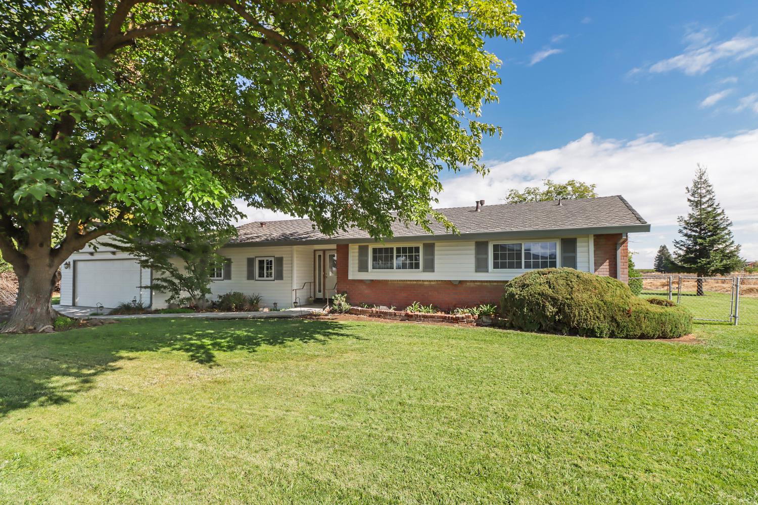a front view of a house with a yard and trees