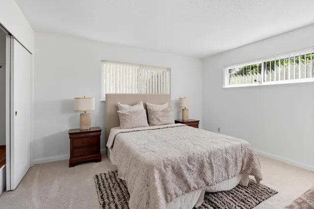 a bathroom with a granite countertop sink a toilet and a mirror