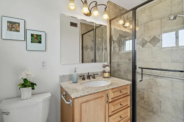 a bathroom with a sink mirror and a toilet