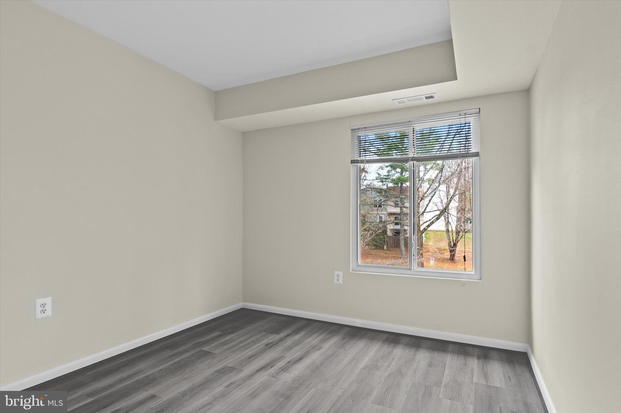 10350 Luria Commons Court, Unit 3H Burke, VA 22015 - Photo 20 of 22 an empty room with wooden floor and windows