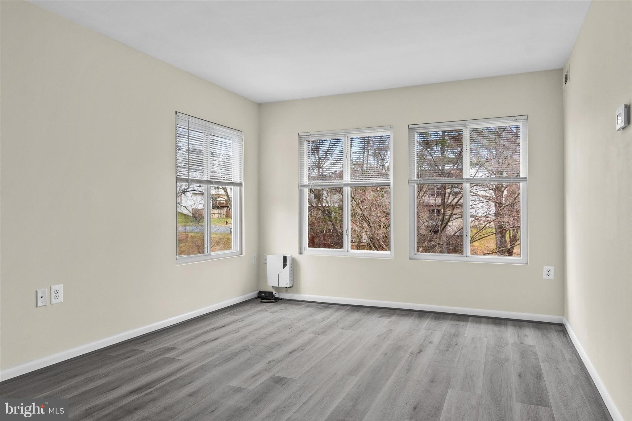 10350 Luria Commons Court, Unit 3H Burke, VA 22015 - Photo 6 of 22 an empty room with wooden floor and windows