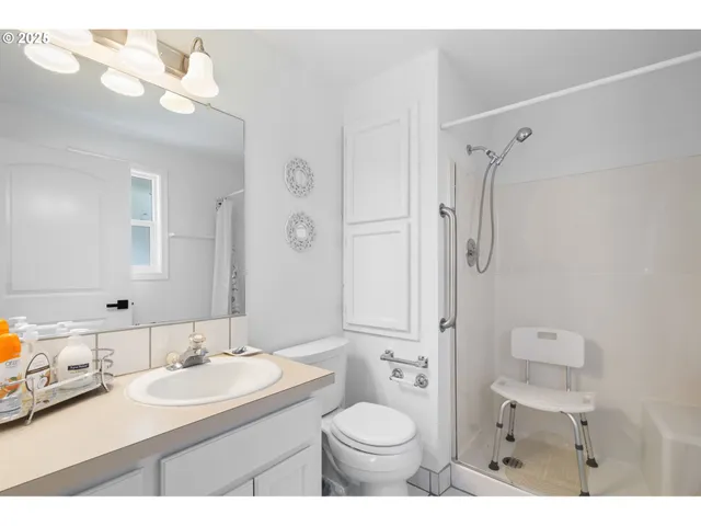 a bathroom with a sink toilet vanity and shower