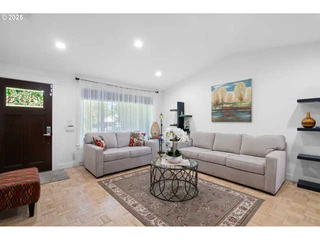 a living room with furniture a flat screen tv and a window