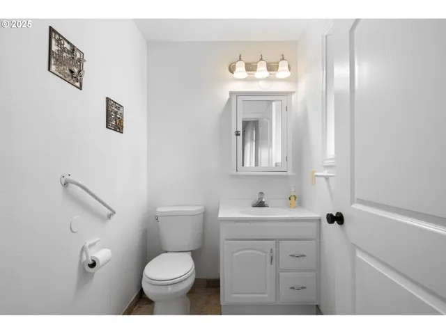 a bathroom with a toilet sink a mirror and vanity
