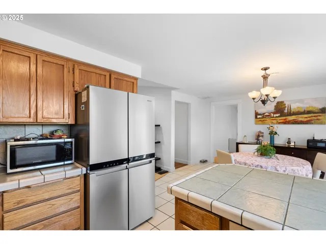 a room with a bed a dresser and a refrigerator