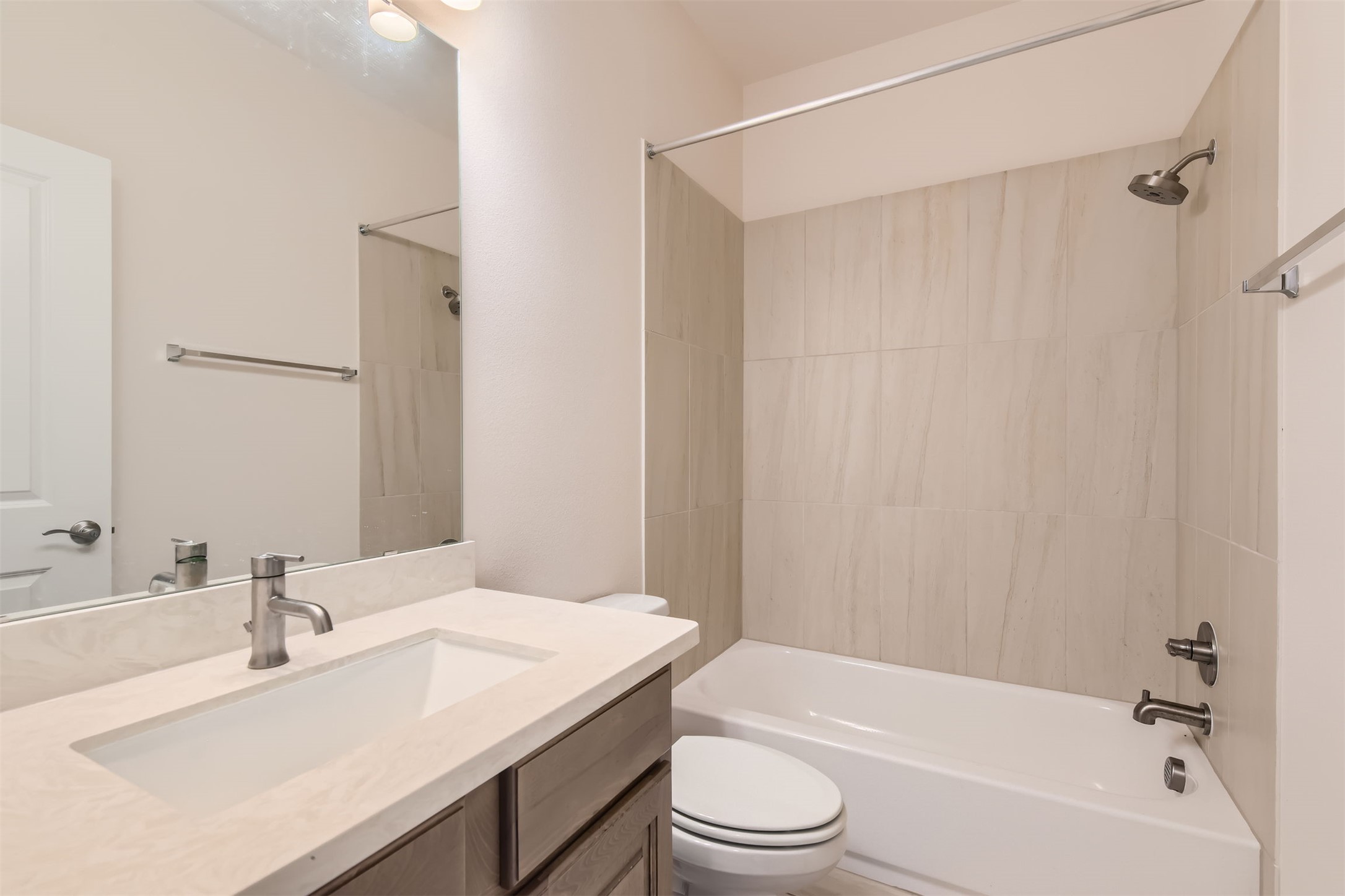 8313 Spire View Austin, TX 78744 - Photo 22 of 33 A well-appointed bathroom features a single vanity, a modern toilet, and a combined tub and shower.