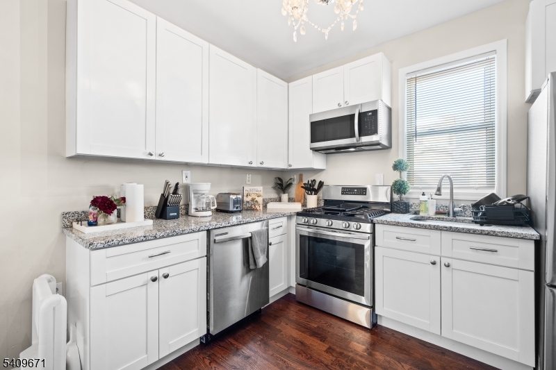 33 Mapes Avenue, Unit 2 Newark, NJ 07112 - Photo 13 of 40 a kitchen with stainless steel appliances granite countertop a sink and stove top oven