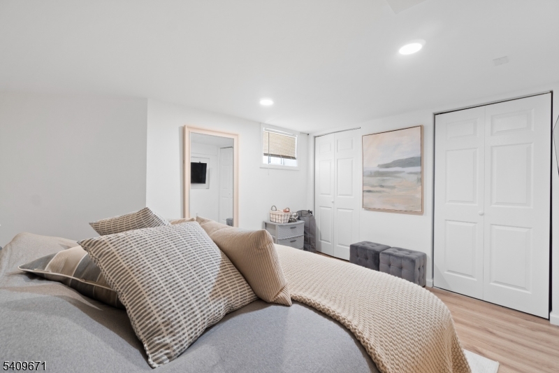 33 Mapes Avenue, Unit 2 Newark, NJ 07112 - Photo 18 of 40 a bedroom with a large bed and a chandelier