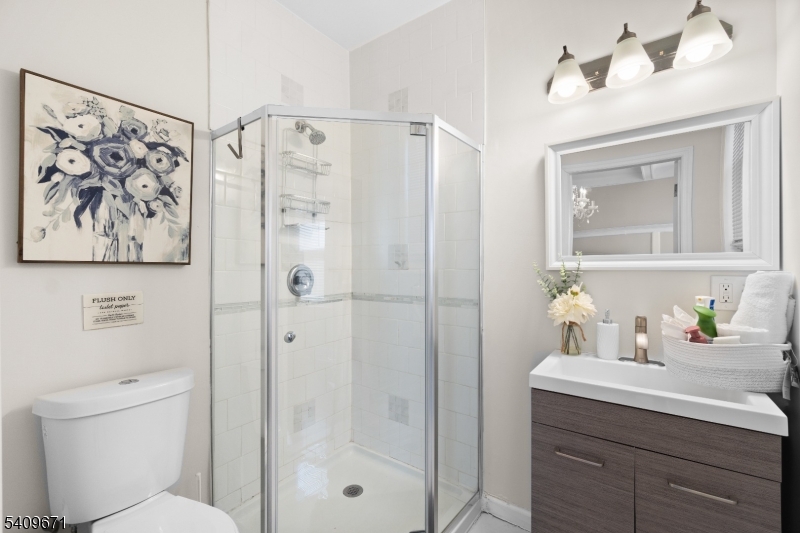 33 Mapes Avenue, Unit 2 Newark, NJ 07112 - Photo 32 of 40 a bathroom with a shower a sink and a mirror