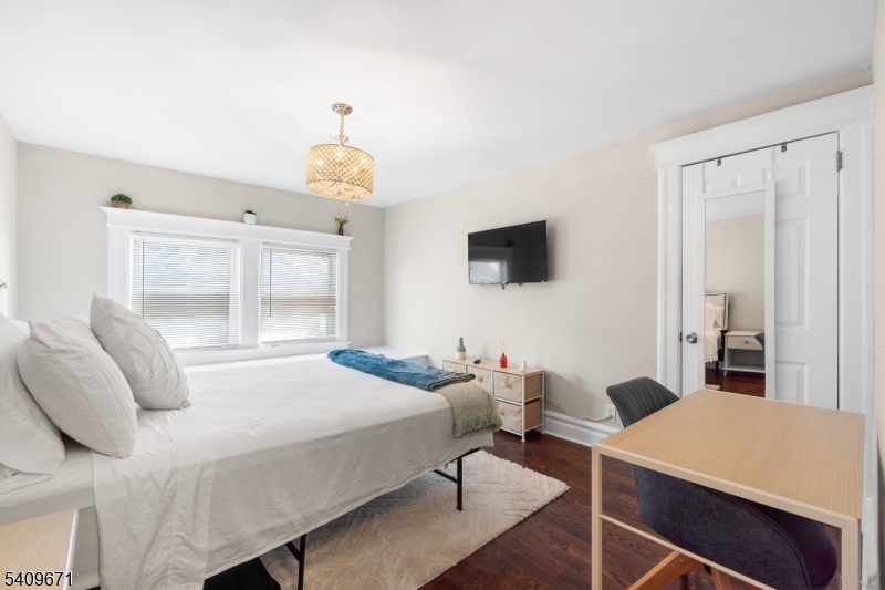 33 Mapes Avenue, Unit 2 Newark, NJ 07112 - Photo 37 of 40 a bedroom with a bed and a chandelier